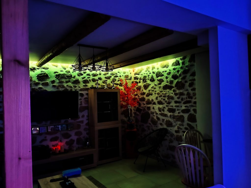 Das Wohnzimmer der Unterkunft luxury house in Irapetra. Im Hintergrund die grün angeleuchtete Steinwand der Wohnung.