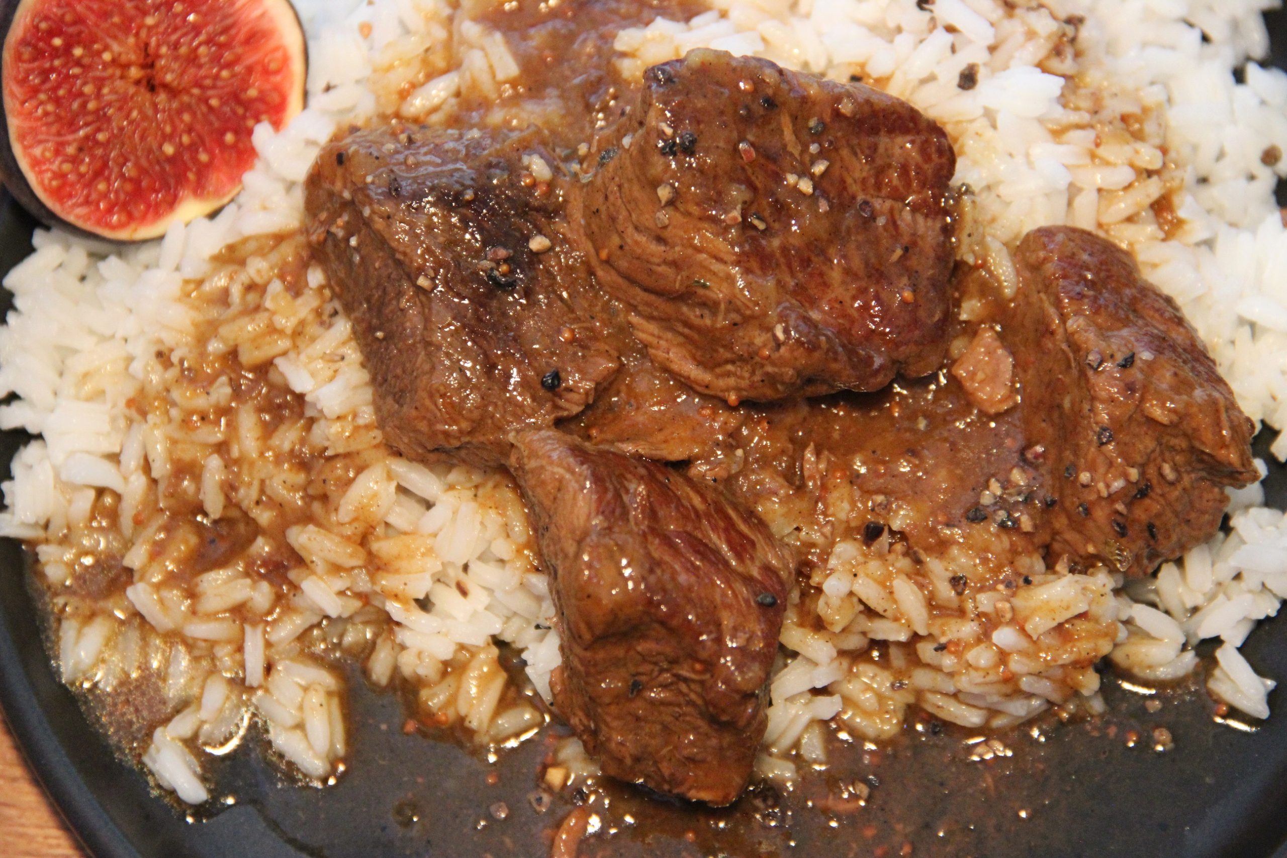 Rindfleisch mit Feigen und Orange mit Reis angerichtet.